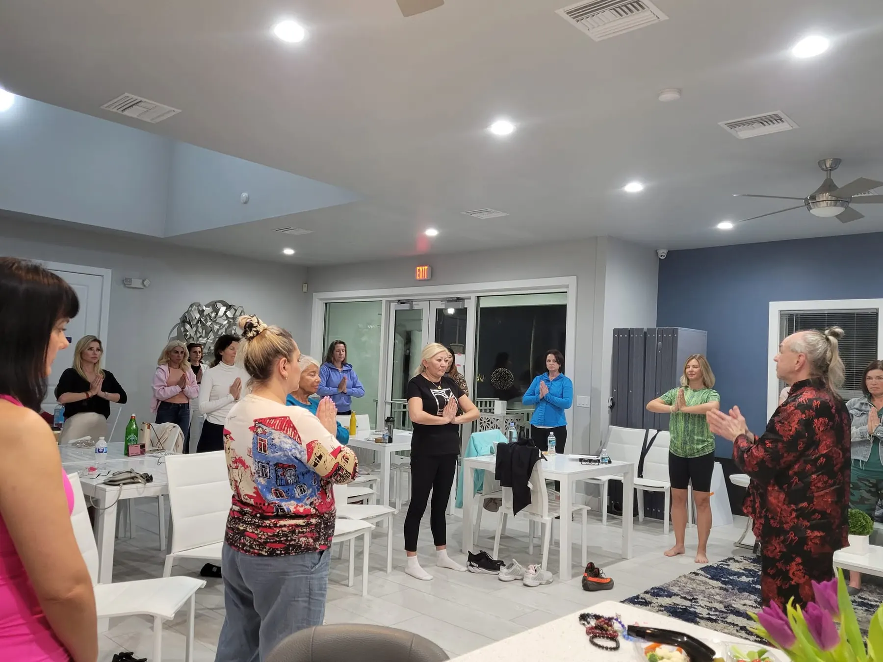 Master Iurii Khomiakov leading a Qigong group class of adult students standing with palms together