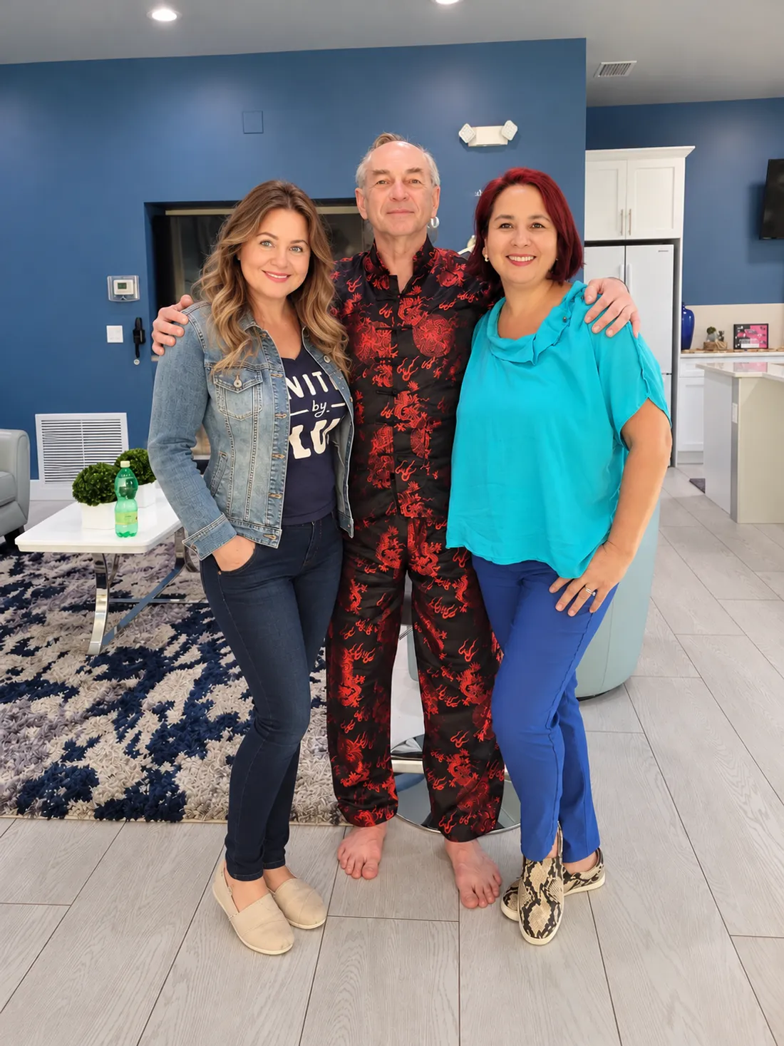 Iurii Khomiakov standing barefoot in his dragon-pattern Qigong suit with his wife and Tima